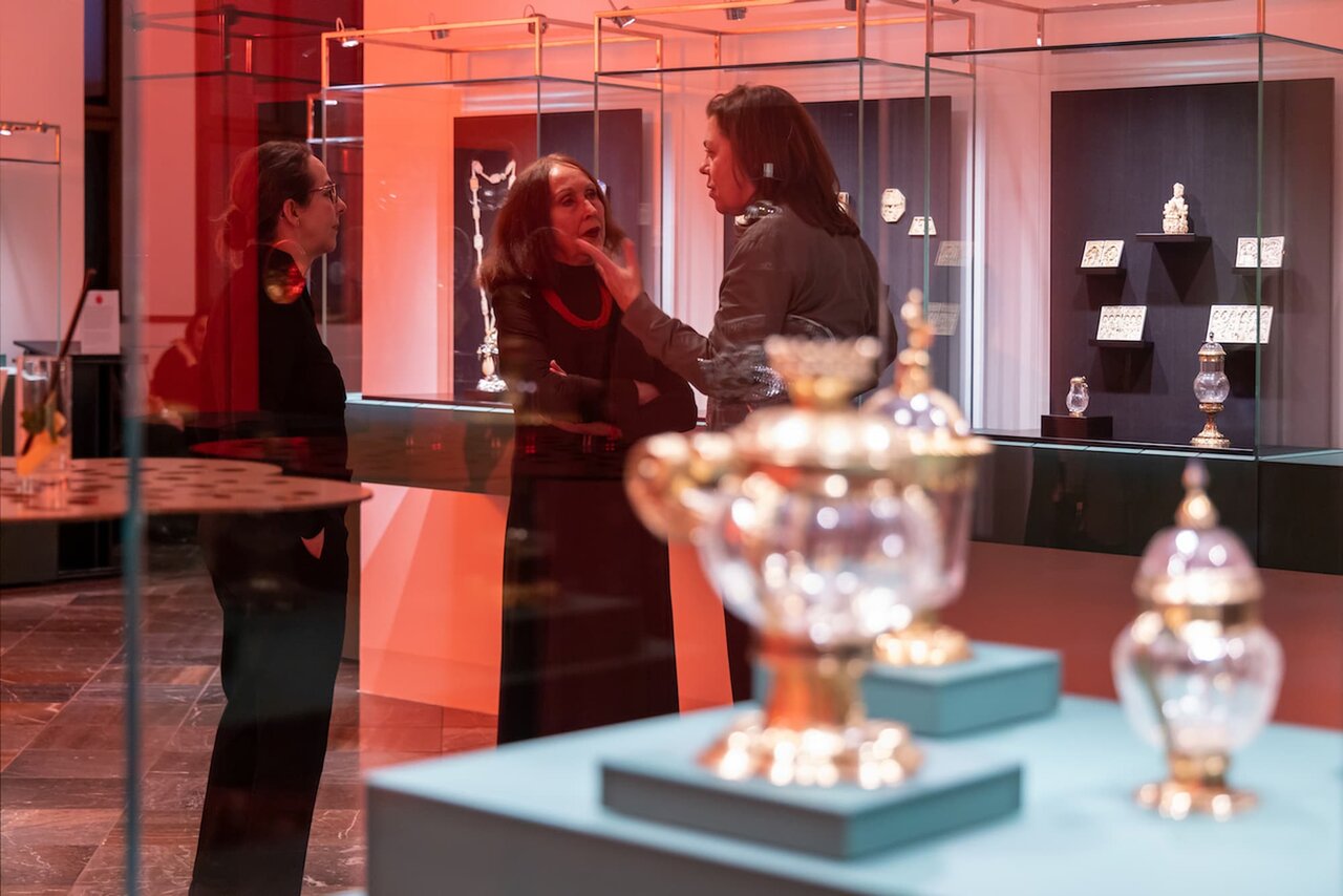 Im Vordergrund sind Kunststücke zu erkennen, im Hintergrund unterhalten sich drei Personen miteinander im Foyer des Historischen Grünen Gewölbes